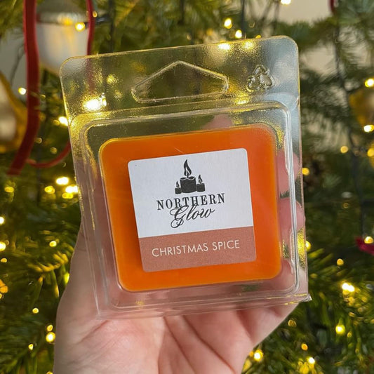 Christmas Spice wax melt is an orange colour in a plastic case. It has four individual cubes that can be split. The label is white with the logo in the centre. 'Christmas Spice' is in white writing with an orange background.