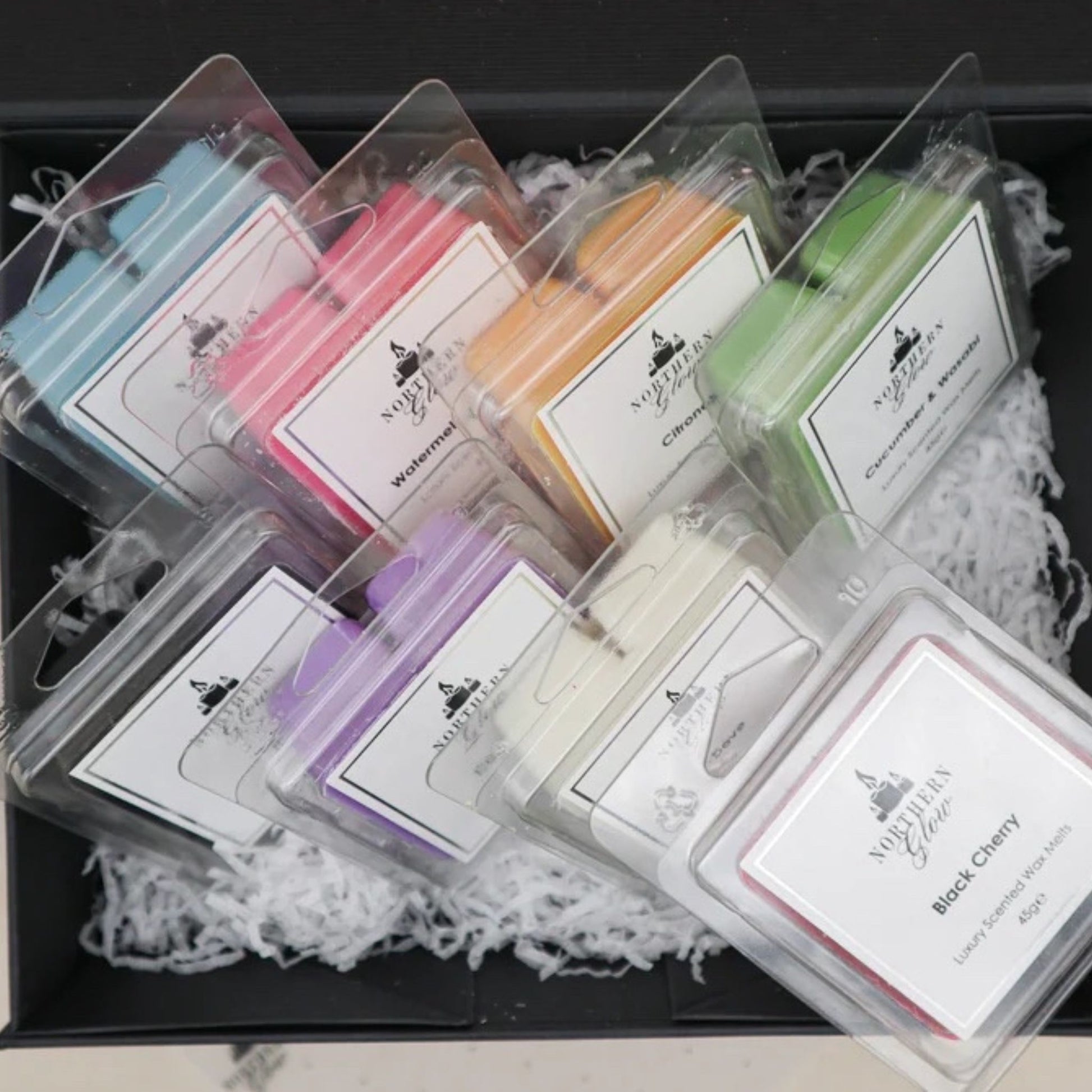 Gift box set with all eight fragrances inside the box, they are all different colours and the wax melts are in a plastic case with white lables and silver writing.