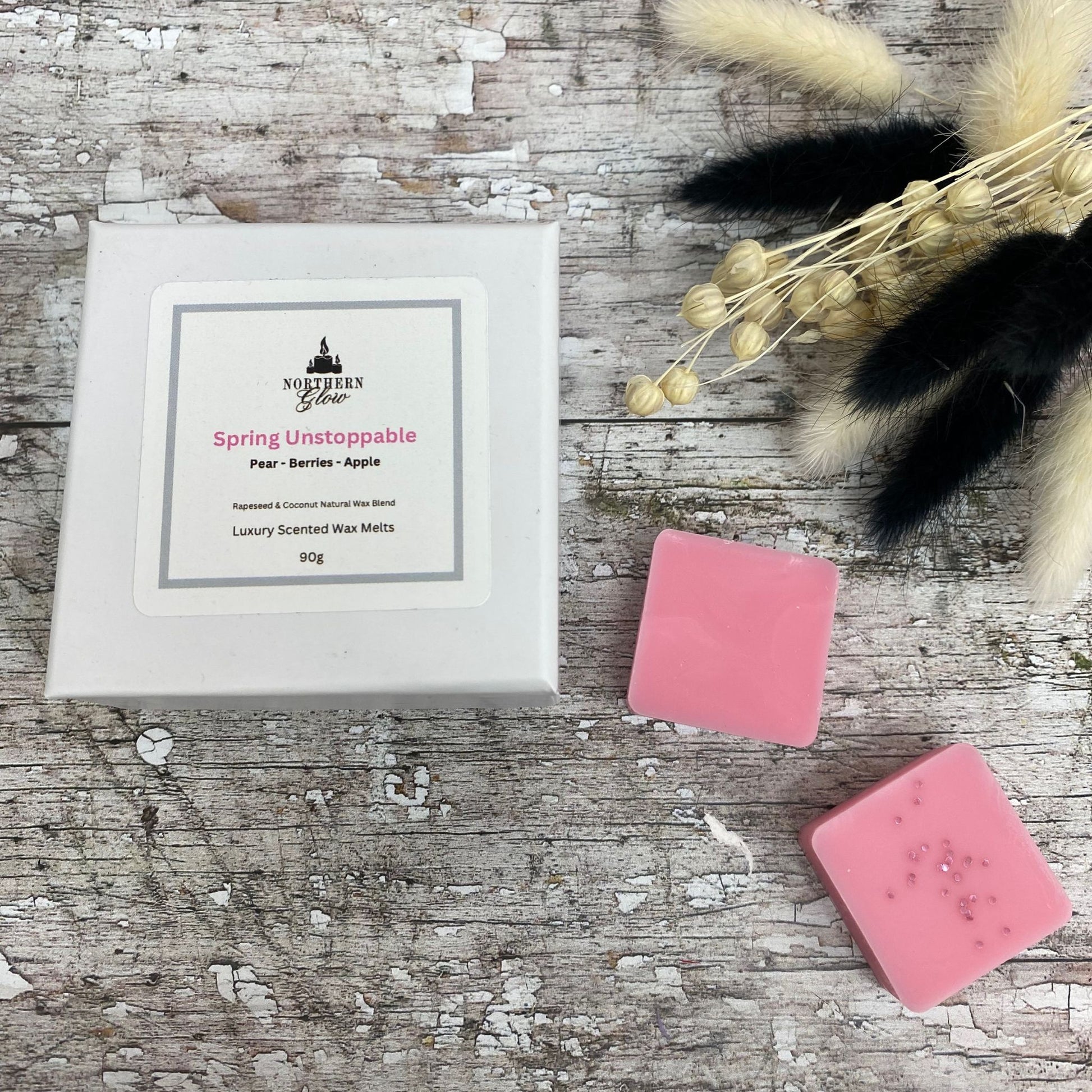 Spring Unstoppable wax melt is a pink colour and each melt is a square shape in a white box. There are eight individual wax melts in the white box. The lablel is white with a silver border. The logo is at the top with 'Spring Unstoppable' in pink writing in the centre.