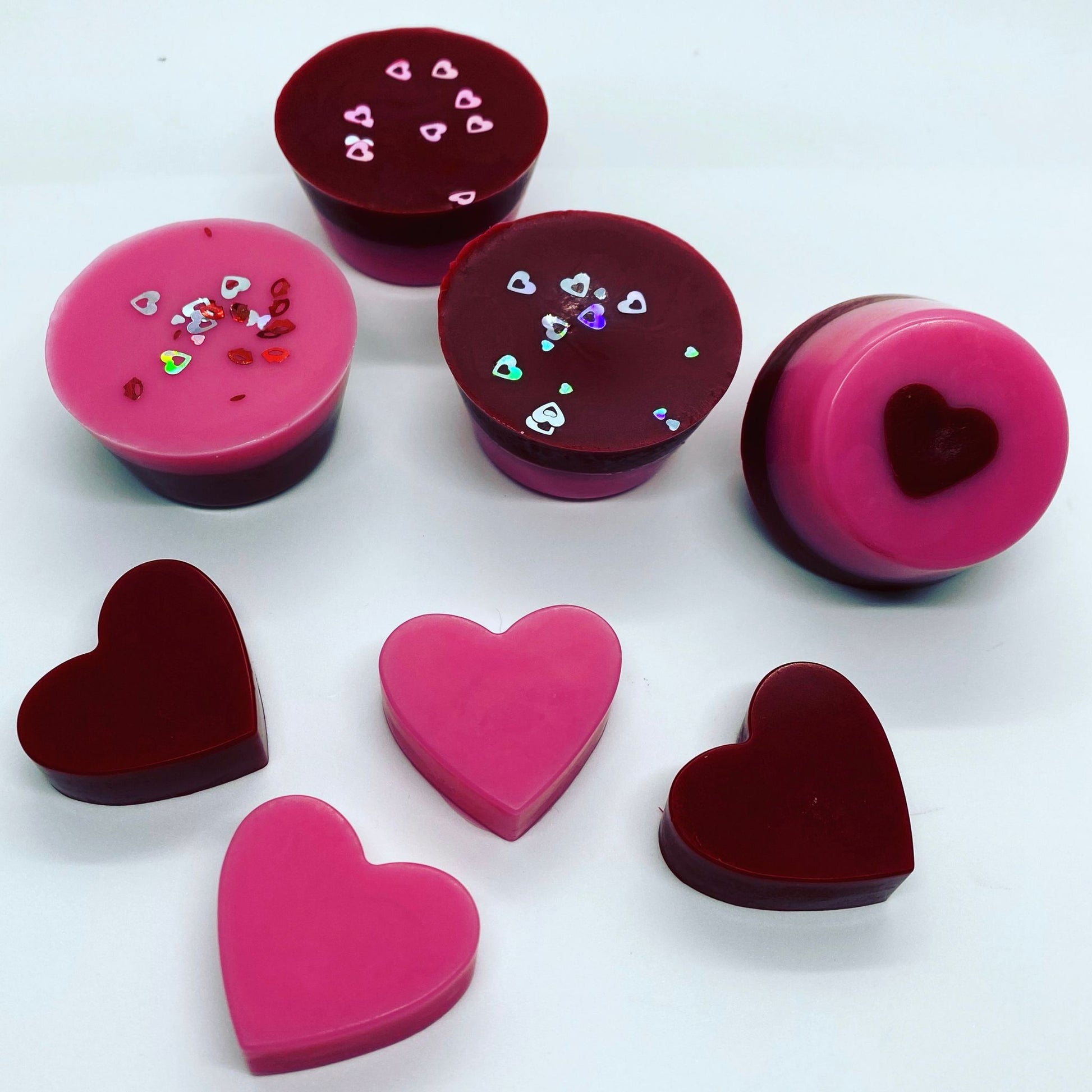 Valentines wax melts are pink and red colour in the shape of hears and round pudding shapes, they have glitter on 