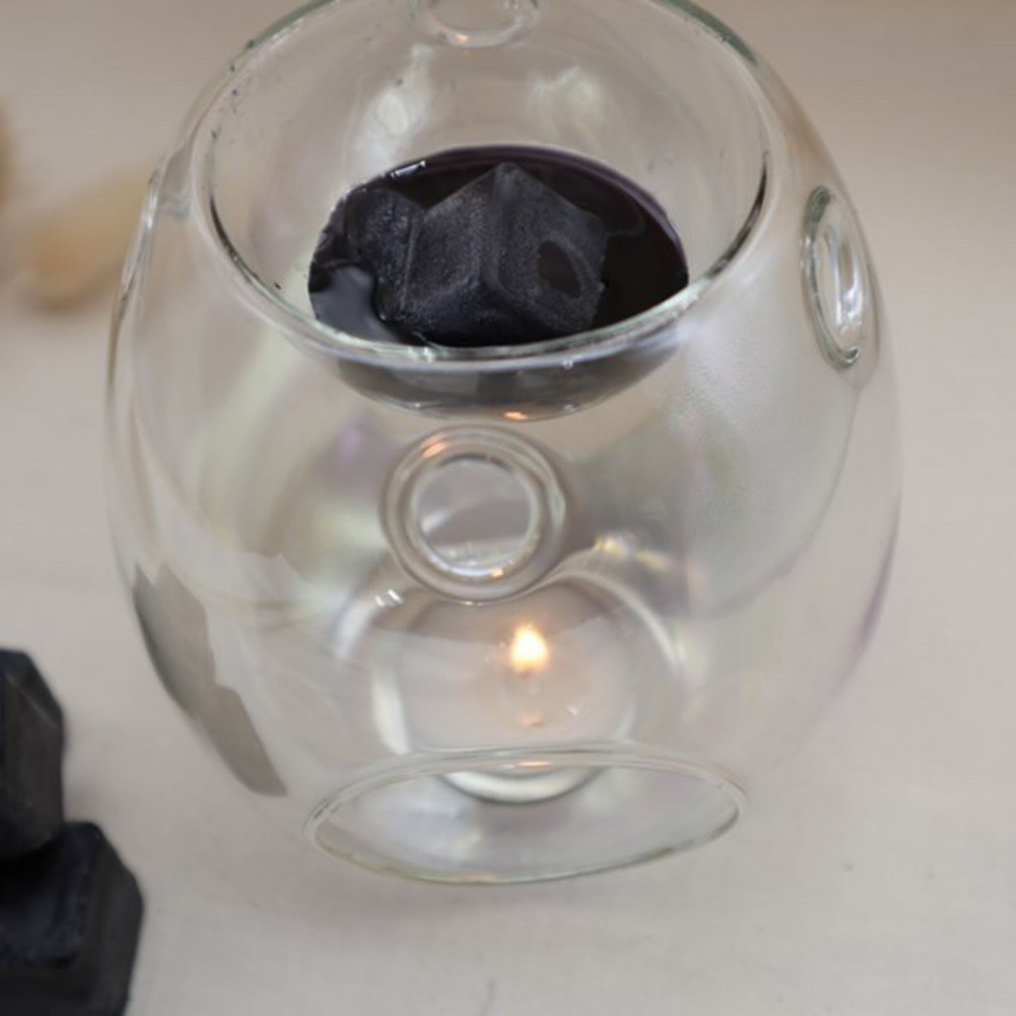 This grey colour glass burner has a black wax melt melting in the top with a tealight in the bottom